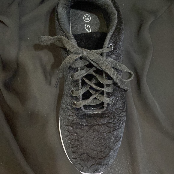 These are black sneakers with a rose design in the cloth on the outside. - Picture 2 of 4